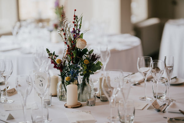 Flowers and candles on crisp white table linen